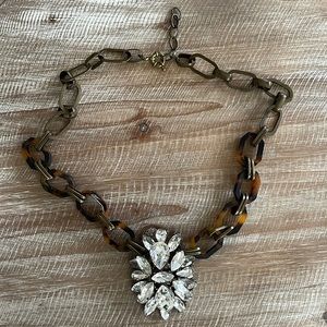 Necklace with jeweled starburst and tortoise chain